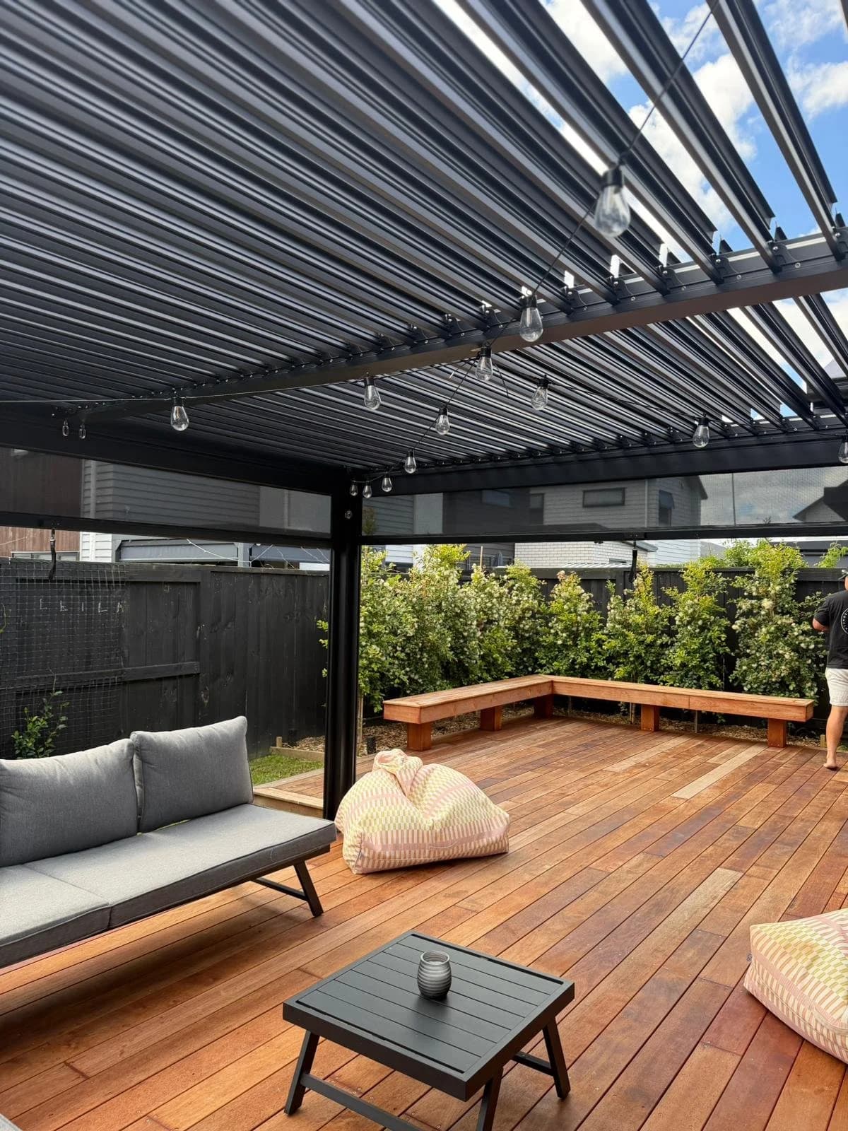 A covered outdoor extension matched to the existing home's roofline and cladding.