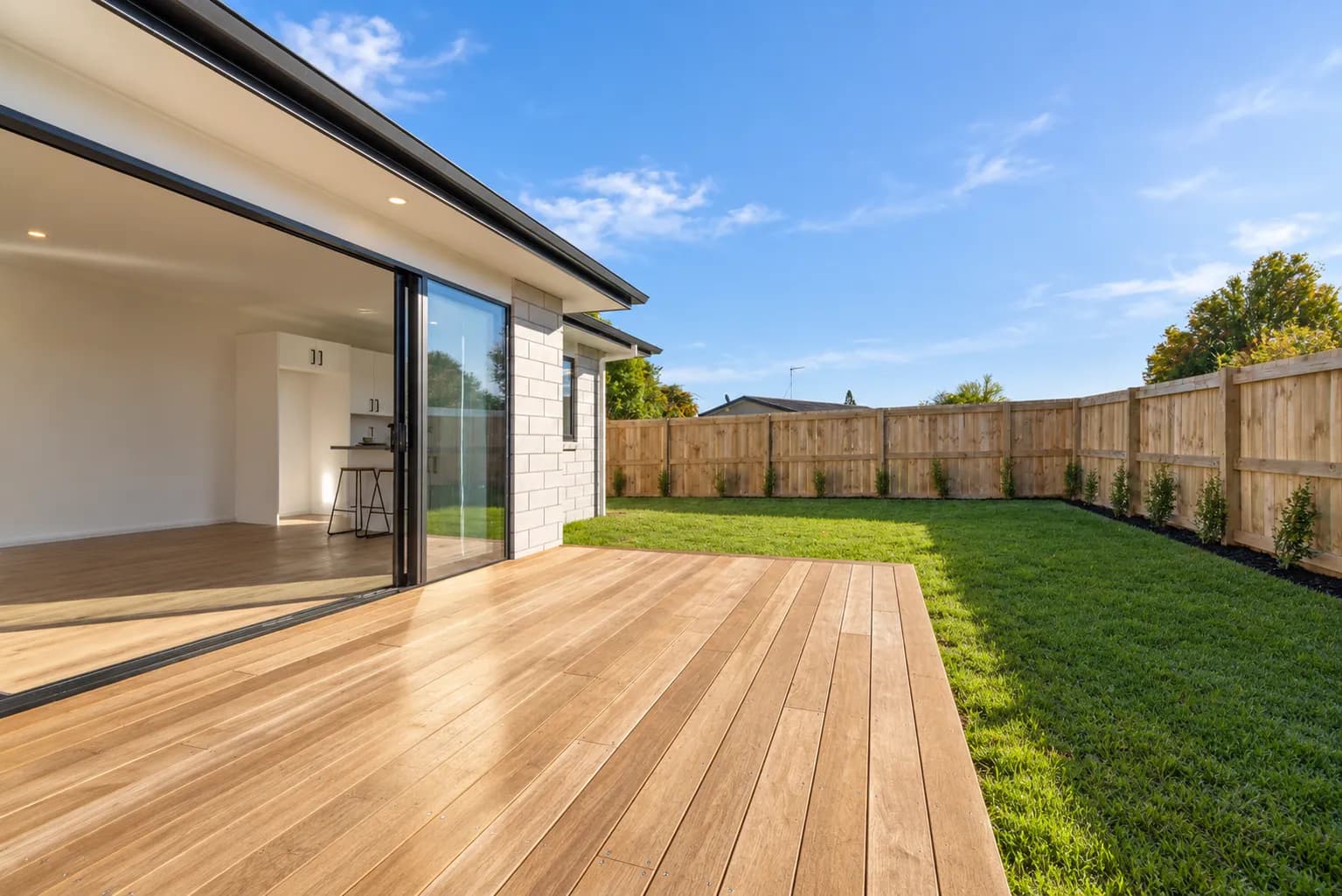 A timber fence and matching deck built by Finer Builds.