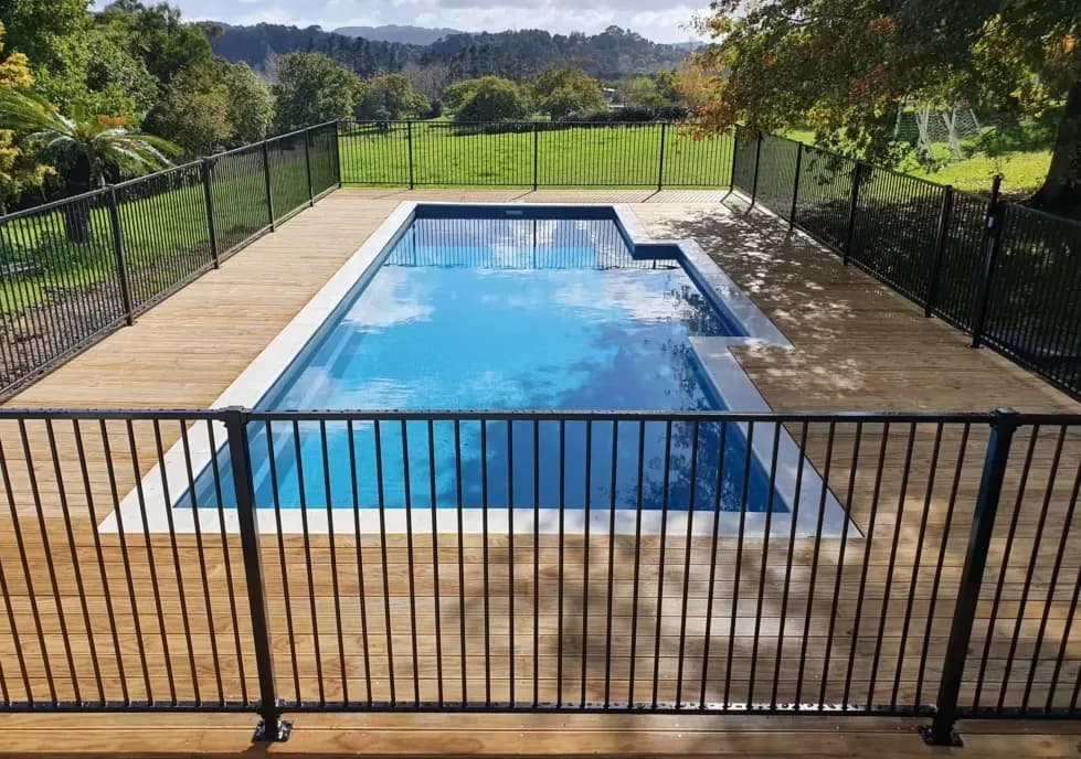 A compliant pool fence and surrounding deck built by Finer Builds.